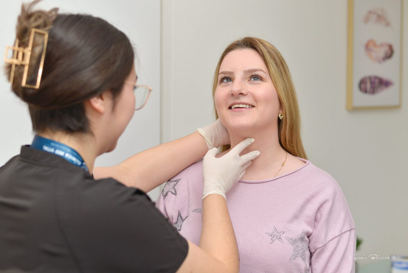 Profesional examina el cuello de una paciente durante la consulta